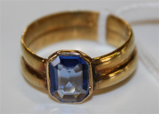 A gold double shanked ring with blue paste stone.